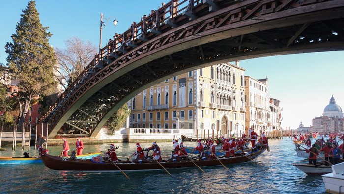 People dressed as Santa Claus row during a Christmas regatta along the Grand Canal in Venice, Italy, December 17, 2023. REUTERS/Manuel Silvestri