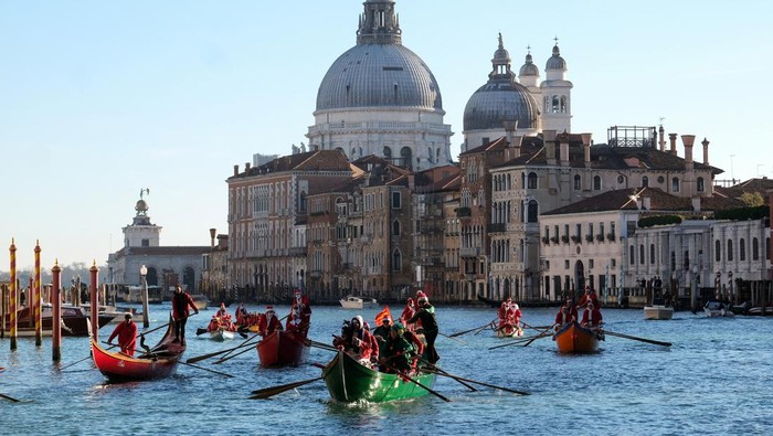 People dressed as Santa Claus row during a Christmas regatta along the Grand Canal in Venice, Italy, December 17, 2023. REUTERS/Manuel Silvestri