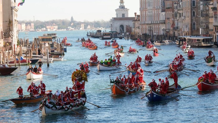 People dressed as Santa Claus row during a Christmas regatta along the Grand Canal in Venice, Italy, December 17, 2023. REUTERS/Manuel Silvestri