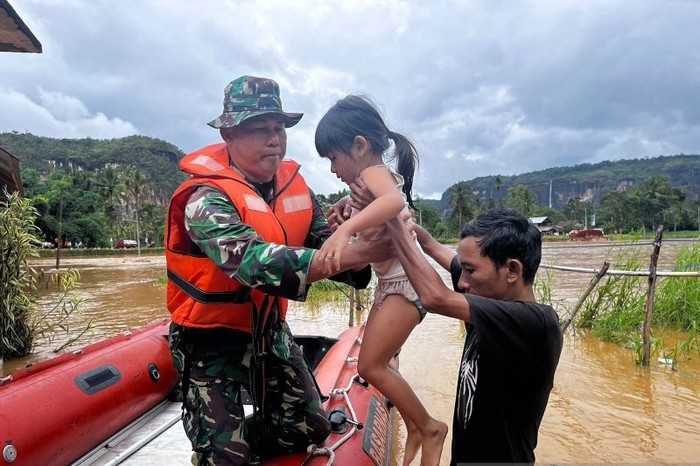 Seumlah petugas gabungan dari Basarnas Padang, TNI, Polri dan BPBD Limapuluh Kota evakuasi warga dari banjir. (ANTARA/HO-Basarnas Padang)