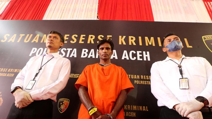 Tersangka penyelundupan pengungsi Rohingya Tersangka Muhammad Amin (tengah) dikawal personel Satreskrim Polresta Banda Aceh saat rilis kasus penyelundupan manusia di Banda Aceh, Aceh, Senin (18/12/2023). Polresta Banda Aceh menetapkan imigran etnik Rohingya Muhammad Amin (35) sebagai tersangka yang menyeludupkan 136 orang pengungsi Rohingya penghuni kamp penampungan Coxs Bazar Bangladesh ke Desa Lamreh, Kabupaten Aceh Besar. ANTARA FOTO/Irwansyah Putra/rwa.