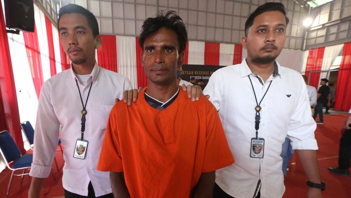 Tersangka Muhammad Amin (tengah) dikawal personel Satreskrim Polresta Banda Aceh saat rilis kasus penyelundupan manusia di Banda Aceh, Aceh, Senin (18/12/2023). Polresta Banda Aceh menetapkan imigran etnik Rohingya Muhammad Amin (35) sebagai tersangka yang menyeludupkan 136 orang pengungsi Rohingya penghuni kamp penampungan Coxs Bazar Bangladesh ke Desa Lamreh, Kabupaten Aceh Besar. ANTARA FOTO/Irwansyah Putra/rwa.
