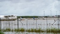 Banjir merendam sejumlah pesawat yang terparkir di Bandara Cairns, Australia, Senin (18/12/2023). AAP Image/Nuno Avendano via Reuters.