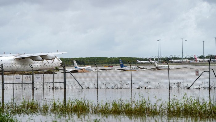 Banjir Bikin Jalan Terbelah-Bandara Terendam di Australia Banjir yang melanda Cairns, Australia, mengakibarkan bandara terendam dan jalanan terbelah, Senin (18/12/2023).