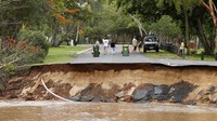 Banjir juga mengakibatkan jalanan terbelah di kawasan Pantai Holloways, Cairns, Australia. AAP Image/Joshua Prieto via Reuters.