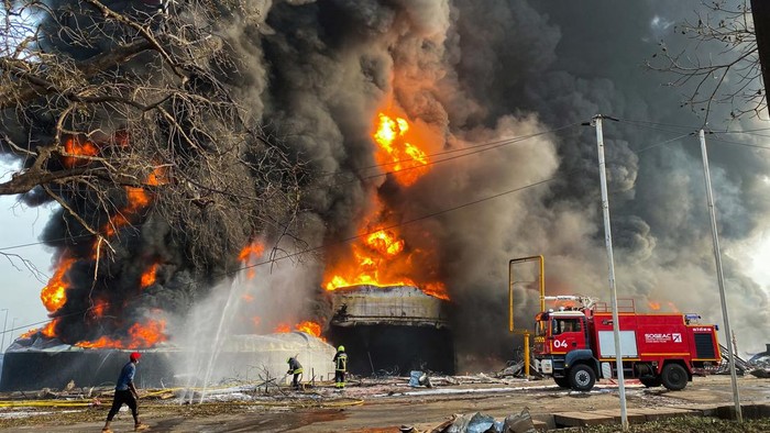 Duar! Kilang Minyak di Guinea Meledak dan Terbakar Firemen monitor the fire after a blast at an oil terminal in Conakry, Guinea December 18, 2023. REUTERS/Souleymane Camara NO RESALES. NO ARCHIVES