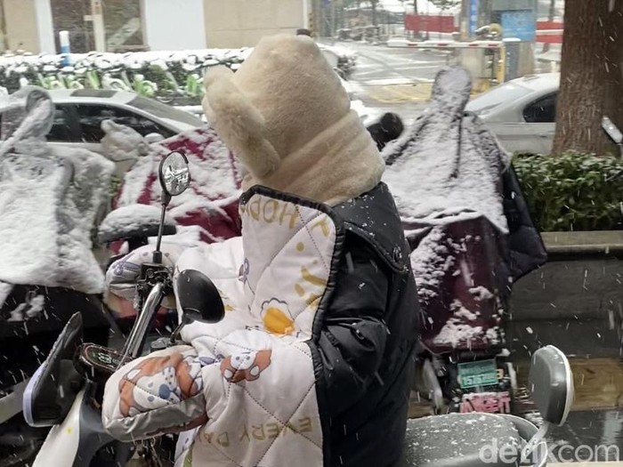 Naik motor pakai selimut saat musim dingin di China
