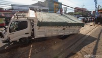 Roda truk masuk ke dalam selokan. Tampak penutup gorong-gorong rusak.