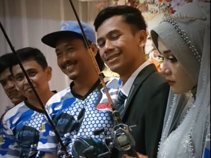 Video yang memperlihatkan pengantin yang ikut memegang kail pancingan, viral di media sosial