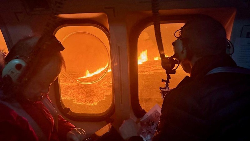 A helicopter flies near a volcano spewing lava and smoke as it erupts near Grindavik, Iceland, December 19, 2023. Icelandic Coast Guard/Handout via REUTERS THIS IMAGE HAS BEEN SUPPLIED BY A THIRD PARTY. NO RESALES. NO ARCHIVES. MANDATORY CREDIT