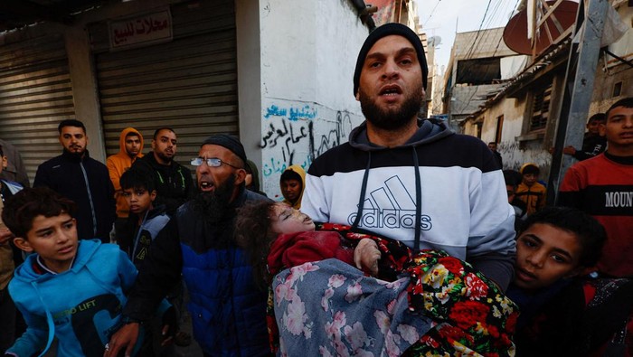 A Palestinian boy carries a wounded child at Nasser hospital following Israeli strikes, amid the ongoing conflict between Israel and Palestinian Islamist group Hamas, in Khan Younis in the southern Gaza Strip, December 9, 2023. REUTERS/Ibraheem Abu Mustafa