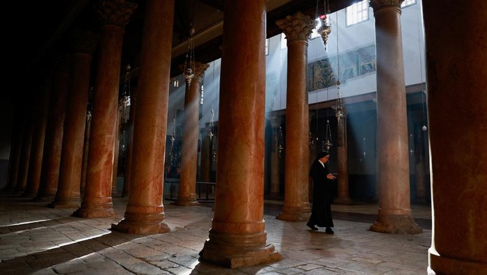 Bethlehem Rayakan Natal Tanpa Pohon Hias karena Berduka untuk Gaza A nun walks at the Church of the Nativity on the day of the launch of the beginning of the Christmas season, as the conflict between Israel and Palestinian Islamist group Hamas continues, in Bethlehem in the Israeli-occupied West Bank December 2, 2023. REUTERS/Ammar Awad