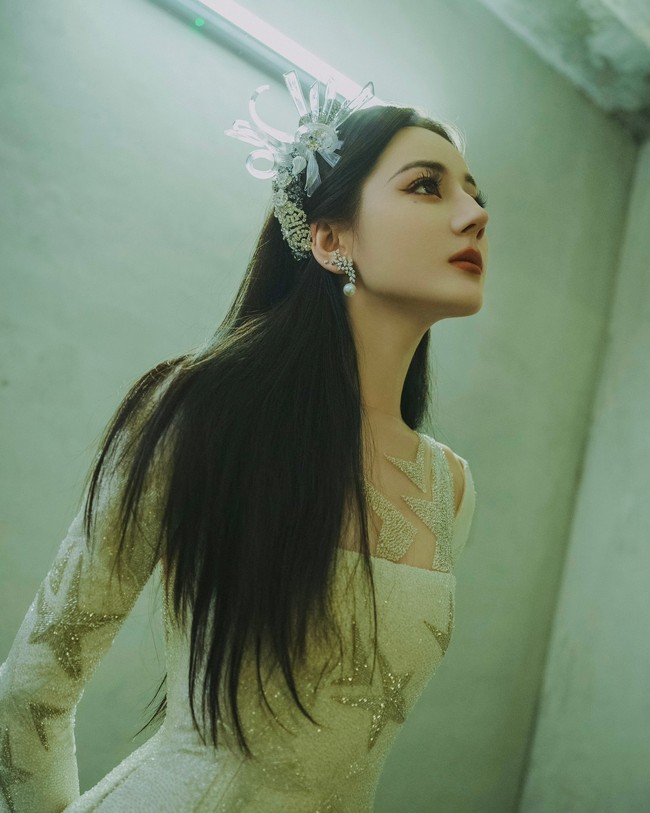 Ia mengenakan gaun haute couture berwarna putih keluaran Julien Fournié. Busana dengan detail kristal dan mutiara itu dipadukan dengan hiasan kepala yang membuat penampilannya bak peri. Foto: Dok. Weibo