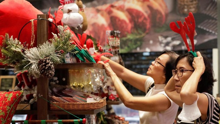 People stand near Christmas decorations at the Central Market PIK in Jakarta, Indonesia, December 19, 2023. REUTERS/Ajeng Dinar Ulfiana