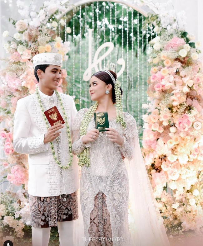 Pernikahan Kayess dan Celiboy mengikuti tradisi adat Jawa. Terlihat keduanya kompak mengenakan pakaian pengantin adat Jawa berwarna putih dipadukan dengan kain batik berwarna coklat. Seperti pasangan lain yang baru menikah, keduanya berpose memamerkan buku nikah mereka. Foto: Instagram/@ewkharis