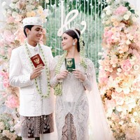 Pernikahan Kayess dan Celiboy mengikuti tradisi adat Jawa. Terlihat keduanya kompak mengenakan pakaian pengantin adat Jawa berwarna putih dipadukan dengan kain batik berwarna coklat. Seperti pasangan lain yang baru menikah, keduanya berpose memamerkan buku nikah mereka. Foto: Instagram/@ewkharis