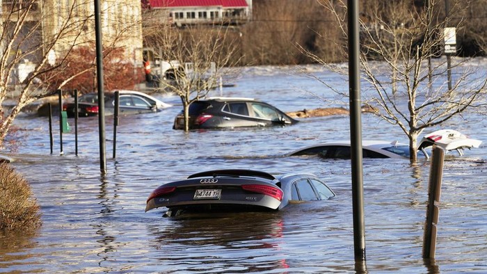 Cars are flooded in a parking lot at the Hathaway Creative Center alongside the Kennebec River, Tuesday, Dec. 19, 2023, in Waterville, Maine. A severe storm on Monday flooded rivers and knocked out power to hundreds of thousands. (AP Photo/Robert F. Bukaty)