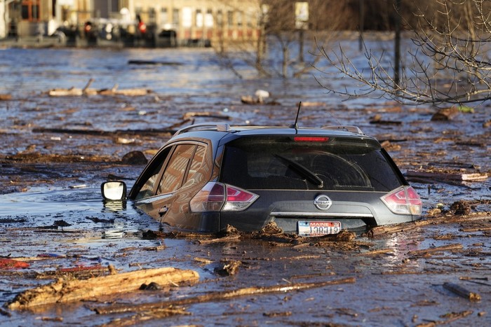 Cars are flooded in a parking lot at the Hathaway Creative Center alongside the Kennebec River, Tuesday, Dec. 19, 2023, in Waterville, Maine. A severe storm on Monday flooded rivers and knocked out power to hundreds of thousands. (AP Photo/Robert F. Bukaty)