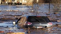 Sebuah mobil mengapung di tempat parkir yang banjir di Hathaway Creative Center di sepanjang Sungai Kennebec di Waterville, Maine, AS, Selasa (19/12/2023).