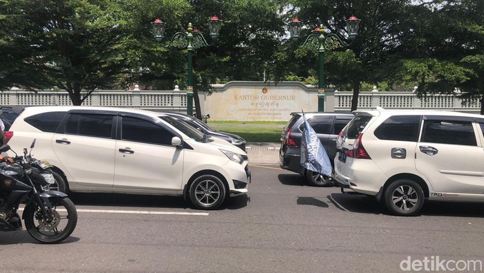 Penampakan parkiran mobil massa driver taksi online yang mengular di Jalan Suryamentaraman, Kota Jogja, Rabu (20/12/2023). Para driver demo mempertanyakan soal Pergub DIY tentang tarif dasar taksi online.