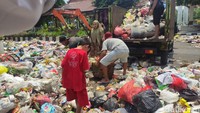Para petugas kebersihan ini membawa banyak sampah dengan gerobak. Saat mereka tidak berhasil menemui bupati, sampah itu dibuang dan ditinggalkan begitu saja di depan pendopo.
