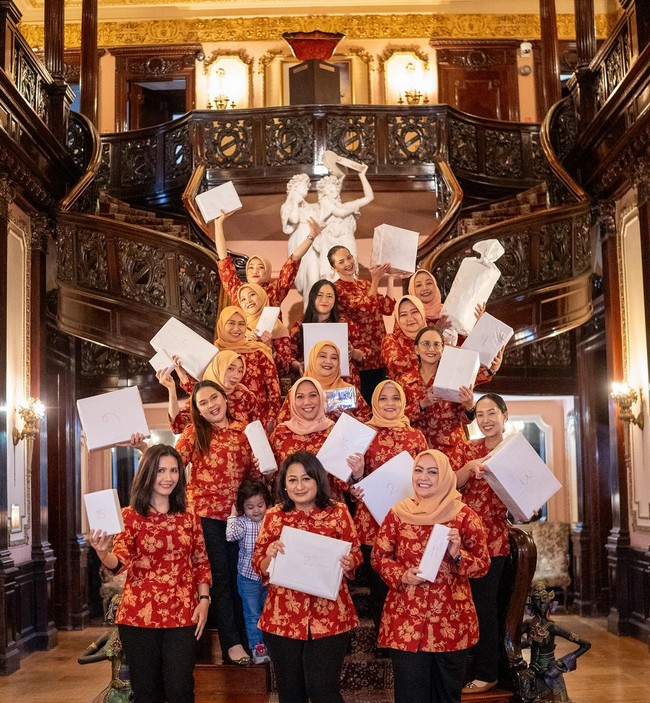 Presenter dan aktris ini mengenakan seragam berupa blouse merah marun motif batik yang dipadu celana hitam. Enzy tampak memakai riasan tipis dan rambutnya disanggul. Foto: Instagram/@enzystoria