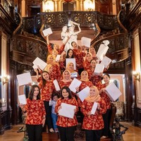 Presenter dan aktris ini mengenakan seragam berupa blouse merah marun motif batik yang dipadu celana hitam. Enzy tampak memakai riasan tipis dan rambutnya disanggul. Foto: Instagram/@enzystoria