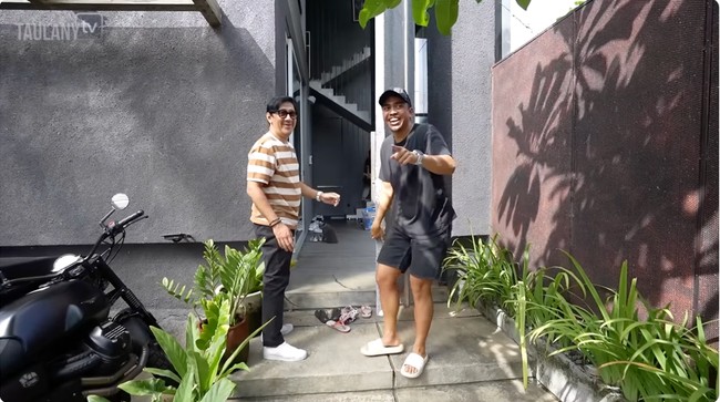 Rumah utama dan kamar tamu sama-sama berdesain minimalis dengan warna abu yang mendominasi. Salah satu fitur unik di rumah utama yang terdiri dari tiga lantai itu adalah pintu depan setinggi 7 meter. (Foto: YouTube/Taulany TV)