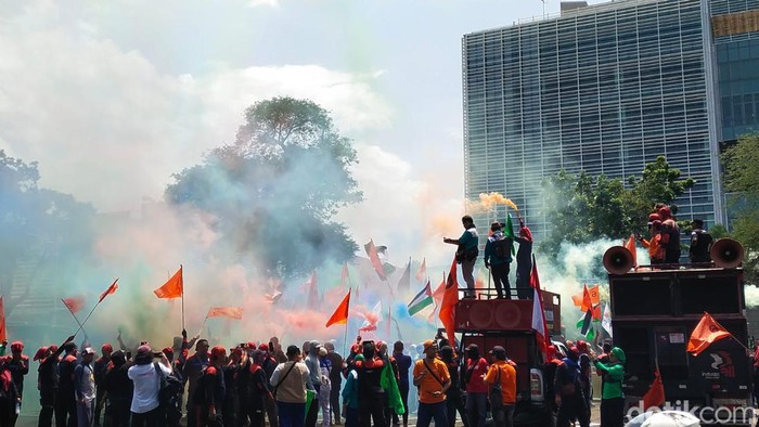 Massa buruh aksi bela Palestina sambil menyalakan flare di depan Kedubes Amerika Serikat (AS), Jakarta Pusat, Kamis (20/12/2023).