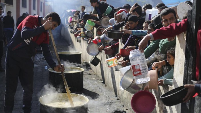 Palestinians line up for a free meal in Rafah, Gaza Strip, Wednesday, Dec. 20, 2023. (AP Photo/Hatem Ali)