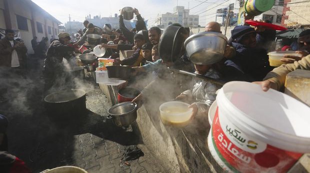 Palestinians line up for a free meal in Rafah, Gaza Strip, Wednesday, Dec. 20, 2023. (AP Photo/Hatem Ali)