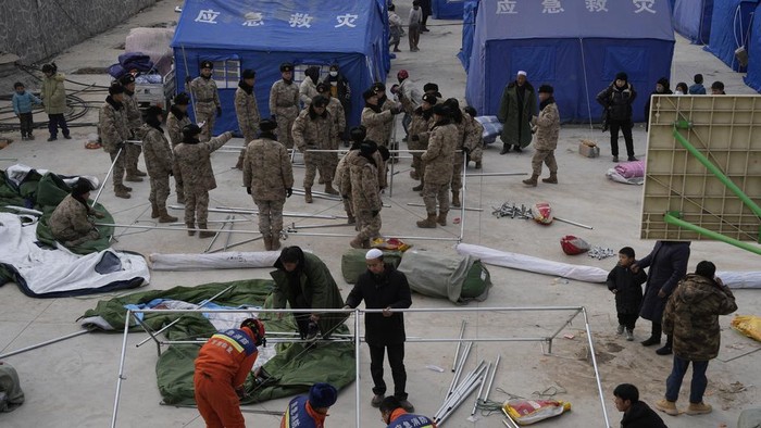 Penampakan Lokasi Pengungsian Korban Gempa China A child stands near tents at a temporary shelter after an earthquake in Dahejia town in northwestern China's Gansu province, Wednesday, Dec. 20, 2023. A strong overnight earthquake rattled a mountainous region of northwestern China, authorities said Tuesday, destroying homes, leaving residents out in a below-freezing winter night and killing many in the nation's deadliest quake in nine years. (AP Photo/Ng Han Guan)