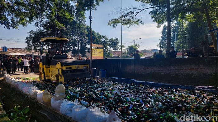 Stoom walls atau alat berat menggilas miras ilegal hasil sitaan Polres Cimahi.