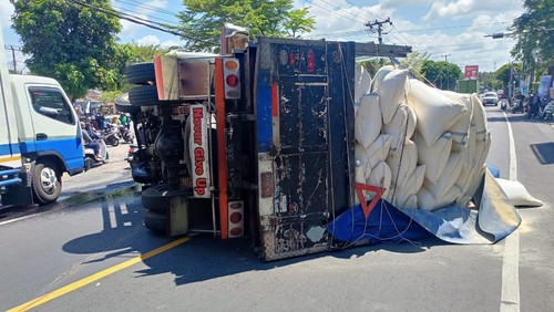 Truk bermuatan bekatul terguling di Jalan Denpasar-Gilimanuk, tepatnya di depan SD Negeri 1 Melaya, Kecamatan Melaya, Kabupaten Jembrana, Bali, Kamis (21/7/2023). (Foto: Dok. Polres Jembrana)