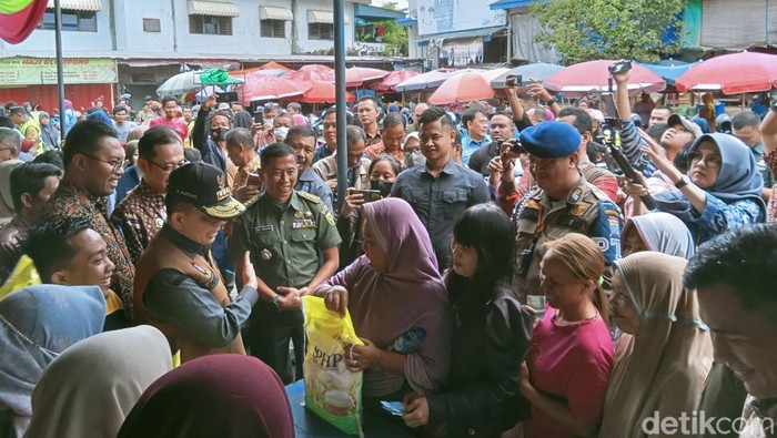 Warga membeli beras murah untuk mendapatkan cabai gratis saat GPM di Pasar KM 5 Palembang.