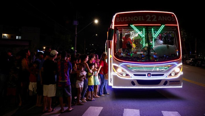 Councilman Edilson Santos, dressed as Santa Claus, poses for a picture outside the 'Bus Noel', a bus decorated by him and his family with Christmas ornaments in Santo Andre, Brazil December 19, 2023. REUTERS/Amanda Perobelli