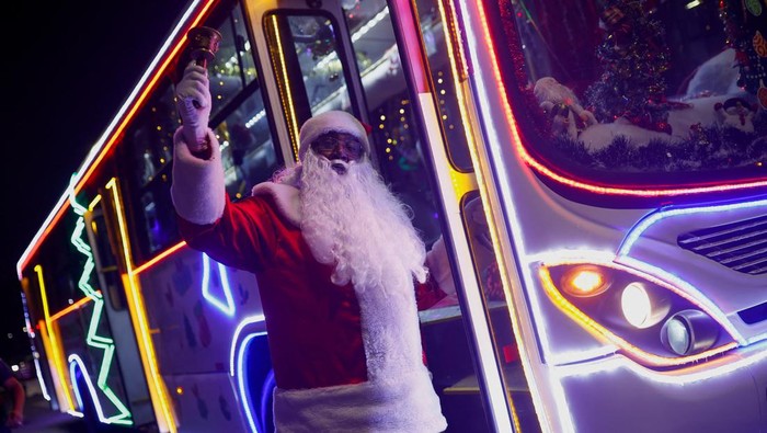 Councilman Edilson Santos, dressed as Santa Claus, poses for a picture outside the 'Bus Noel', a bus decorated by him and his family with Christmas ornaments in Santo Andre, Brazil December 19, 2023. REUTERS/Amanda Perobelli
