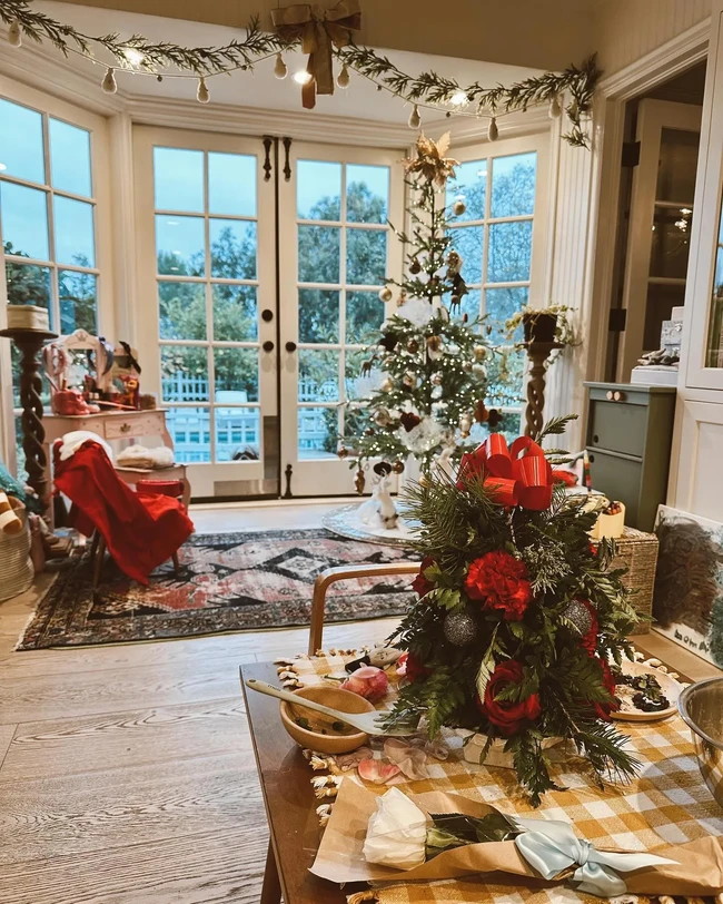 Kate Hudson memilih gaya klasik untuk menghias rumahnya dengan ornamen Natal. Terdapat pohon Natal berhias lampu, bola emas dan centerpiece bentuk pohon Natal mini di meja makan. Foto: Instagram