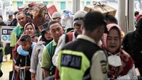 Para penumpang antre memasuki Stasiun Senen.  