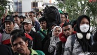 Para penumpang tampak membawa barang bawaan seperti tas besar hingga kardus.  