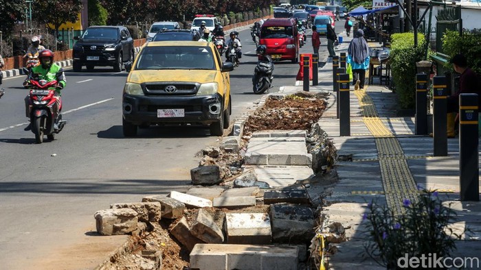 Penampakan Trotoar Margonda yang Dibongkar Lagi Usai Direvitalisasi Trotoar di Jalan Margonda Raya, Depok, yang baru selesai direvitalisasi, dibongkar Pemkot Depok karena masih banjir. Begini penampakannya, Jumat (22/12/2023).