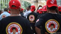 Beberapa kompak mengenakan kaus hitam bergambar cap Gibran di bagian punggung lengkap dengan aksesori berupa topi berwarna merah.
