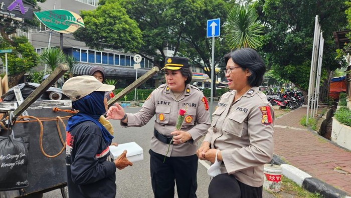 Polwan Polres Jaksel turun ke jalan membagikan makanan hingga bunga untuk kaum ibu di Hari Ibu.