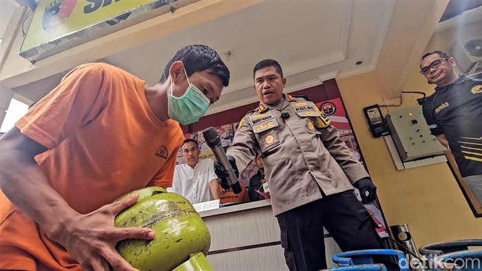Pria inisial RS terlihat membalikan gas 3 kilogram kemudian meletakannya di atas tabung gas 12 kilogram. Ia memindahkan isi tabung gas bersubsidi ke tabung non subsidi.