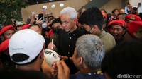 Ganjar juga melayani permintaan tanda tangan di helm milik warga. 