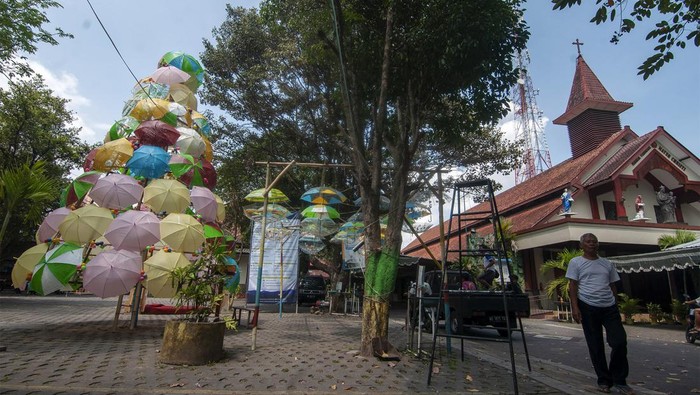 Kreatif, Pohon Natal Ini Terbuat dari Payung Warna-warni Seorang umat melintas di dekat pohon Natal dari susunan payung di Gereja Katolik Santa Perawan Maria Bunda Kristus, Wedi, Klaten, Jawa Tengah, Jumat (22/12/2023). Pohon Natal yang terbuat dari susunan payung warna-warni itu gambaran suka cita kedatangan Tuhan Yesus Kristus sebagai wujud belas kasih Allah yang senantiasa memberi perlindungan kepada seluruh umat manusia. ANTARA FOTO/Aloysius Jarot Nugroho/rwa.