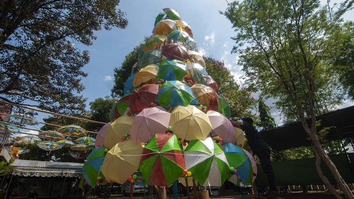 Kreatif, Pohon Natal Ini Terbuat dari Payung Warna-warni Seorang umat melintas di dekat pohon Natal dari susunan payung di Gereja Katolik Santa Perawan Maria Bunda Kristus, Wedi, Klaten, Jawa Tengah, Jumat (22/12/2023). Pohon Natal yang terbuat dari susunan payung warna-warni itu gambaran suka cita kedatangan Tuhan Yesus Kristus sebagai wujud belas kasih Allah yang senantiasa memberi perlindungan kepada seluruh umat manusia. ANTARA FOTO/Aloysius Jarot Nugroho/rwa.