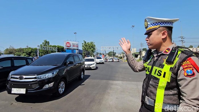 Petugas tengah melakukan pengaturan arus lalu lintas di simpang Karanglo.