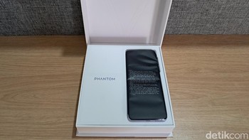 Begini penampakannya saat kotak pertama kali dibuka, disuguhkan ponsel yang dibalut plastik hitam. Foto: detikINET/Josina