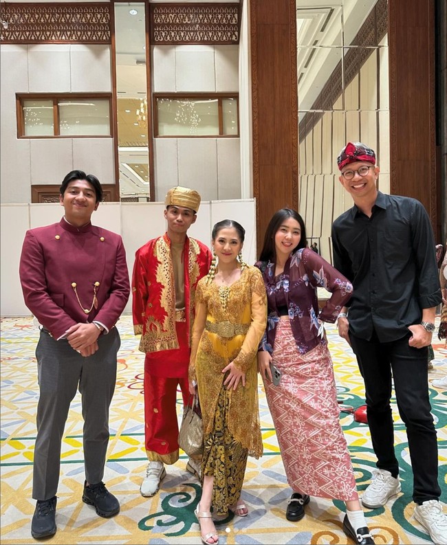Ikat pinggang dari bahan kuningan mengaksentuasi busananya. Mantan personil JKT48 ini melengkapi penampilannya dengan tote bag dan strap heels bernuansa emas. Foto: Instagram/@yudistardhana @harrisvriza
